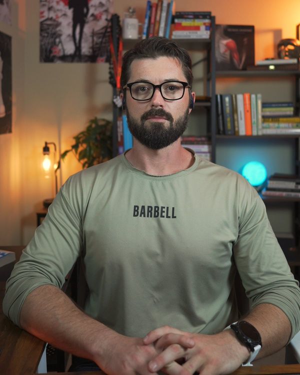 Ryan Tullis, The Boring Fitness Coach, sitting at his desk in his studio